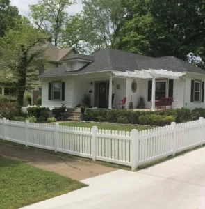 A custom white picket residential fence built by trusted Chattanooga fence company All Fences Co. enclosing a beautiful front yard of a white house.